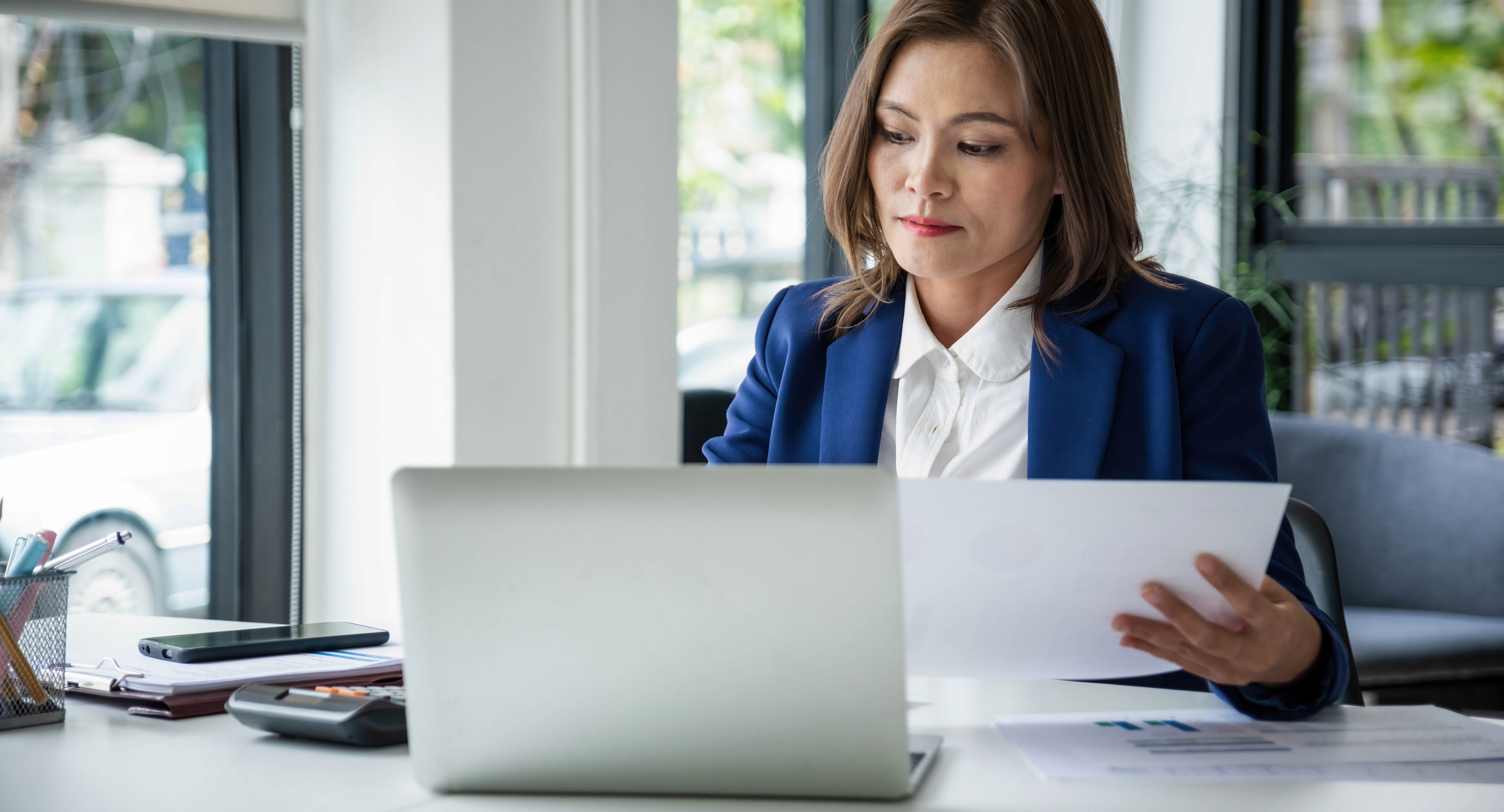 woman looking over business plans at laptop
